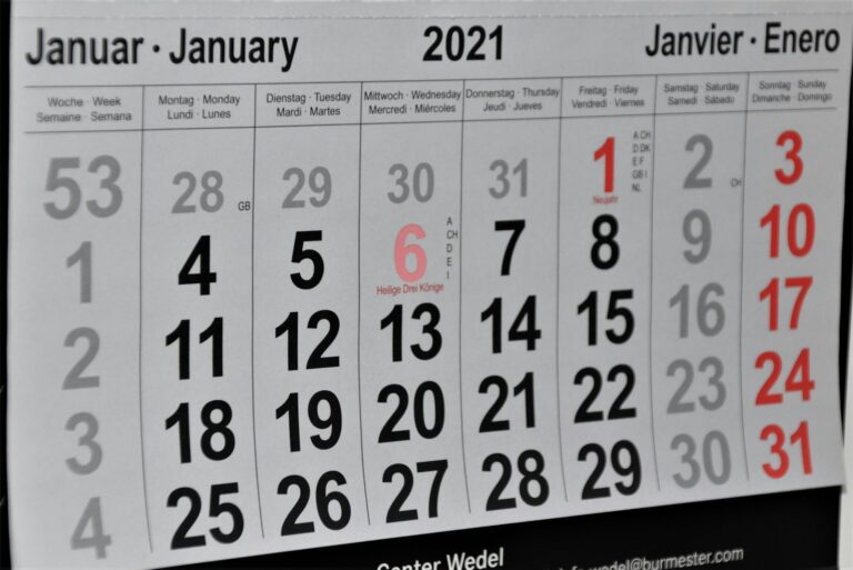 Een meertalige kalenderpagina voor januari 2021 met data in het Duits, Engels, Frans en Spaans. Zondagen zijn rood gemarkeerd. 6 januari is gemarkeerd als "Heilige Drei Könige." Kalenderweken zijn links genummerd.